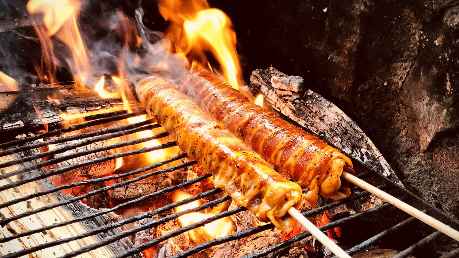 Fleischspiesse über der offenen Glut eines Kanalgrills